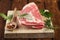 Raw shoulder lamb on wooden board and table