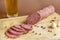 raw smoked sausage on a wooden chopping Board with spices a glass of beer