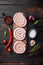 Raw snail sausage in traditional spiral  on old dark wooden table background  top view flat lay