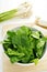 raw spinach, leeks and green garlics on the countertop of a kitchen