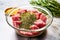 raw steak in a glass bowl, coated with herb rub