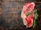 Raw steak of juicy beef with a branch of fragrant rosemary