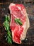 Raw steak of juicy beef with a branch of fragrant rosemary