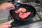 Raw steak meat cows is fried in a cast iron skillet