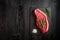 raw strip loin steak on black wooden background