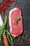 Raw striploin steak or strip New York with herbs. Black background. Top view