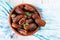 Raw sweet dry dates with in a terracotta bowl on a light blue background. Organic sweeties to healty eating