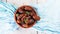 Raw sweet dry dates with in a terracotta bowl on a light blue background. Organic sweeties to healty eating