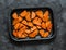 Raw sweet potato slices on a baking tray on a dark background, top view. Cooking baked sweet potatoes