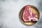 Raw T-bone porterhouse beef meat Steak on golden metalic plate. Gray background. Top view. Copy space
