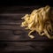 Raw tagliatelle pasta on wooden background