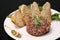 Raw tartar meat with spices, croutons and herbs. Beef tartar with capers. Beef tartar with slices of bread.