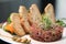 Raw tartar meat with spices, croutons and herbs. Beef tartar with capers. Beef tartar with slices of bread.