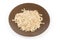 Raw thick-rolled oats on brown dish on white background