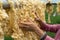 Raw of threads extracted from the cocoon of the silkworm drying outdoor, with Vietnamese woman hands separating the threads