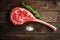 Raw Tomahawk steak on wooden background with spices for grilling