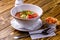 Raw tomato soup, typical food of Spain, served in white bowls with pieces of tomato, cucumber and paprika. Wooden