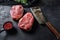 Raw  top blade cut organic meat ner butcher meat clever knife for bbq or gtrill top view over black stone background close upside