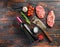 Raw top blade steaks with herbs seasoning and butcher knife near red wine bottle over old dark wooden table top view, space for