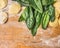 Raw Tortellini with green spinach leaves on wooden background with wheat flour, top view