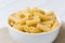 Raw tortiglioni pasta in a white bowl