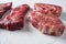 Raw tri-tip triangle roast or bottom sirloin steak near top blade cut organic meat cut side view close up over white concrete