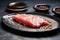 raw tuna steak with seared edges on a ceramic plate