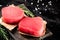 Raw tuna steaks on a rosemary cutting board.