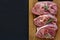 Raw turkey steak meat with bone on wooden board background