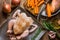 Raw uncooked chicken seasoned in baking tray, rosemary, chopped garnish vegetables carrots potatoes onion garlic, preparing for co