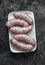 Raw uncooked turkey homemade sausages on dark background, top view. Food ingredient