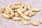 Raw unpeeled peanut nuts in nutshell on light paper background.