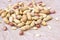 Raw unpeeled peanut nuts in nutshell on light paper background.