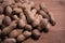 Raw unshelled peanuts close up on natural wooden table background.