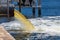 Raw untreated yellow water or sewage being pumped into a blue lake - Hollywood, Florida, USA