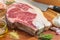 Raw vaca rubia gallega steak on wooden table with kitchen knife and seasonings