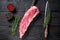 Raw veal calf short spare rib meat with butcher knife. Black wooden background. Top view