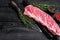 Raw veal calf short spare rib meat with butcher knife. Black wooden background. Top view. Copy space