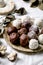 Raw vegan coconut chocolate candy balls over white with eucalyptus branches