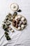 Raw vegan coconut chocolate candy balls over white with eucalyptus branches. Flat lay