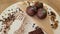 Raw vegan desserts, raw chocolate candies with coconut and cocoa powder, chocolate bar on white plate.