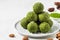 Raw vegan energy balls made of matcha tea, dates and nuts on white background. Healthy vegan dessert