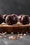 Raw vegan snack. Yummy bliss balls with green buckwheat, nuts and fruits on wooden plate on black background selective focus side