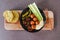 Raw veggies falafels and hummus on cutting board with corn bread