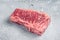 Raw Wagyu striploin or New york steak on a butcher table. Gray background. Top view