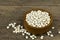 Raw white beans seed in wooden bowl on wooden table background