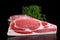 Raw whole back bacon loin with herb on black board background