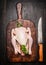 Raw whole chicken on vintage cutting board with kitchen knife on rustic wooden background