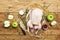 Raw whole duck, green apples, pepper and rosemary. Ready for cook. Wooden background. Top view. Copy space