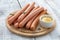 Raw Wiener or Frankfurter sausages with mustard on wooden table.